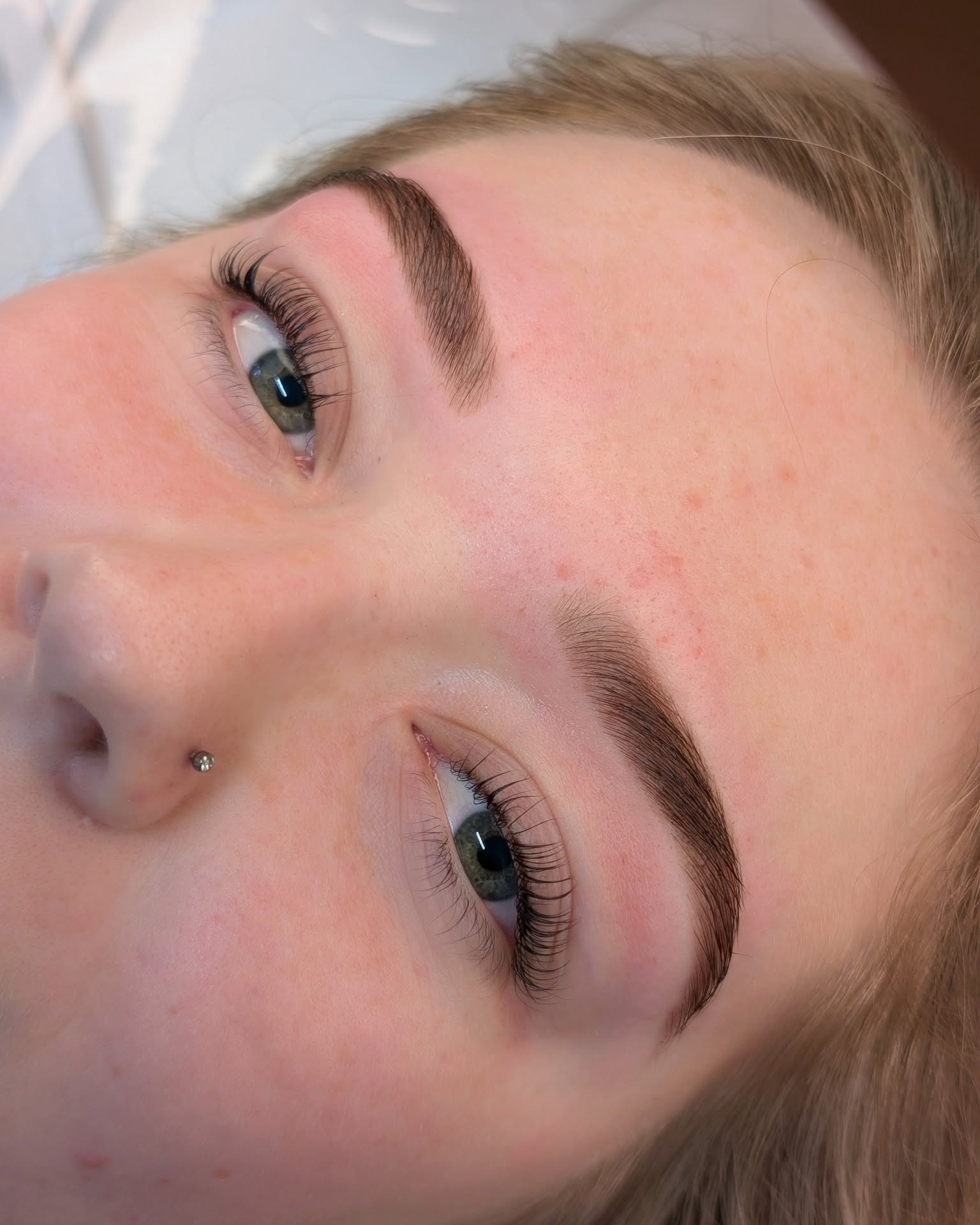 Shaped and tinted brows on a client lying back in the treatment chair