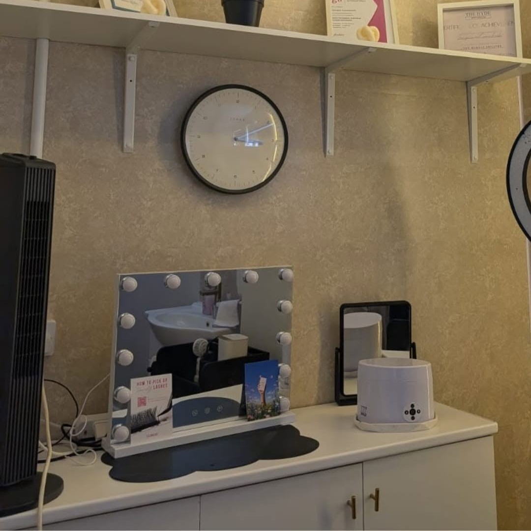 A Hollywood mirror and clock in the treatment room