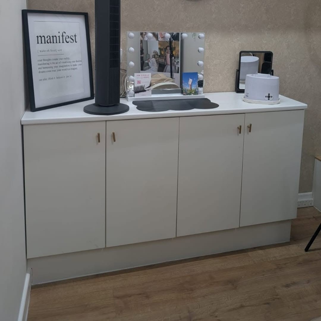 White cabinets and a framed print in the treatment room