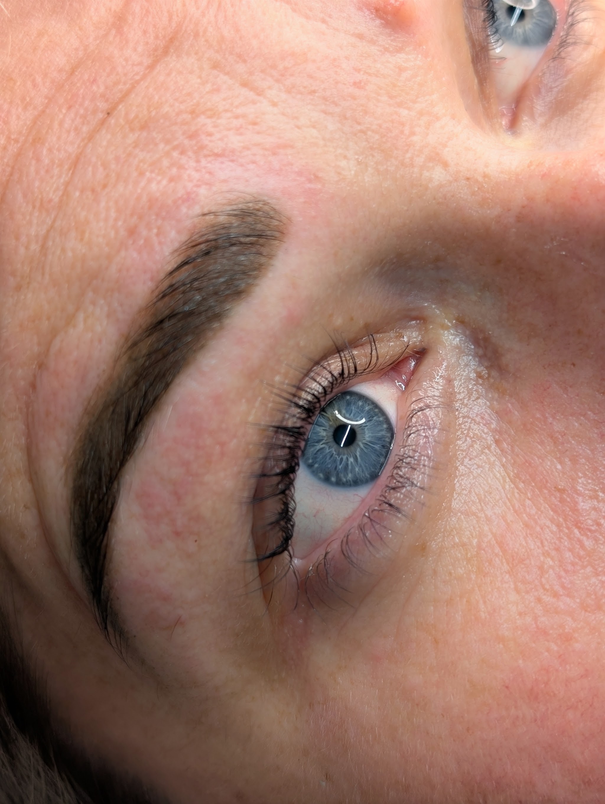 A finished brow above a blue eye